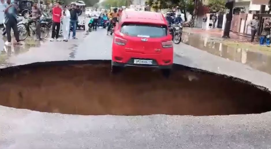 اتر پردیش کے لکھنؤ میں سڑک پھٹنے سے آدھی کار بیچوں بیچ پھنس گئی